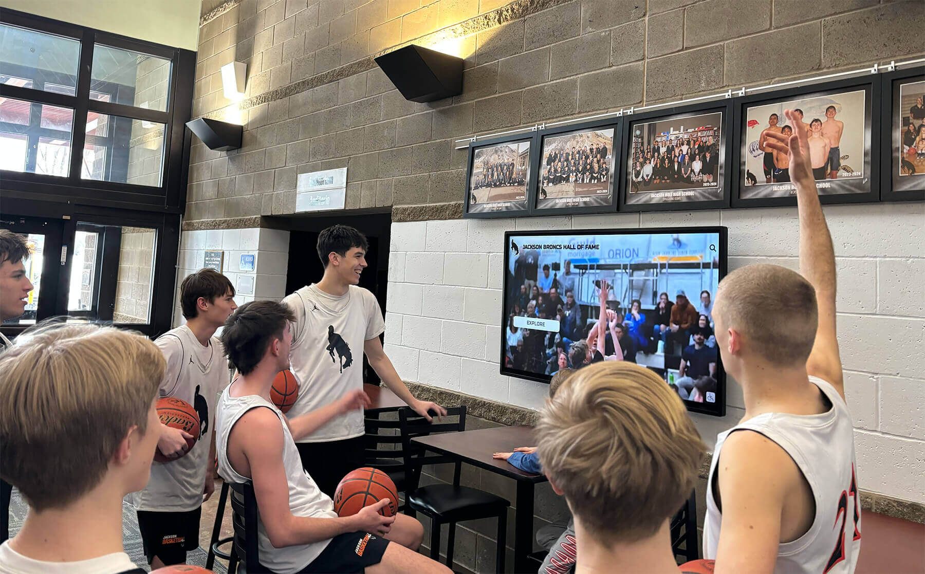 High school basketball players watching highlights on digital display